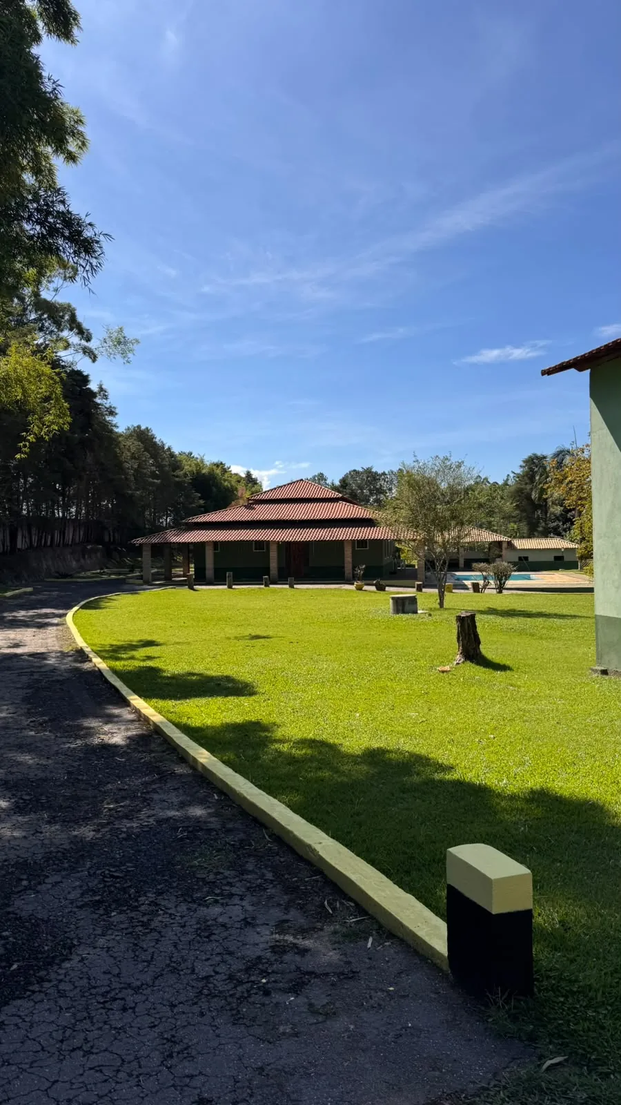 Caminho de pedra entre o gramado e o quiosque, no fim da tarde