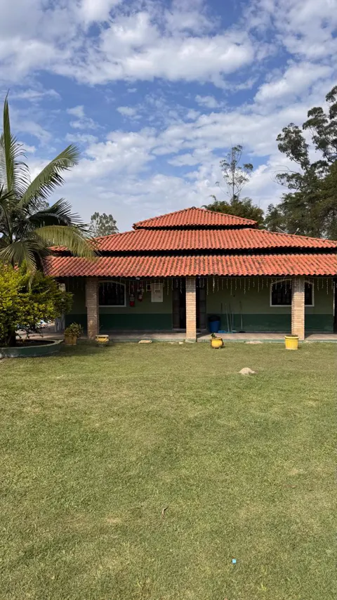 A casa de telhado colonial com varanda, vista do gramado em dia de céu azul