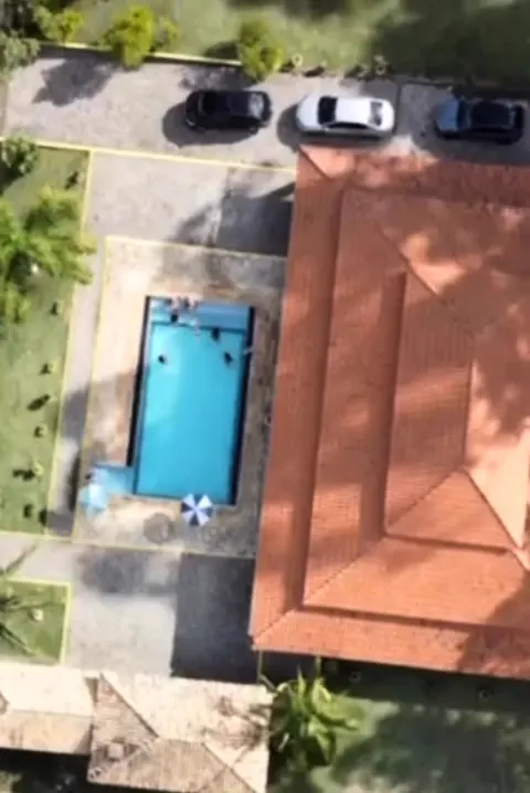 Vista aérea da piscina, da casa e do estacionamento