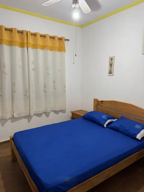 Suíte com cama de casal arrumada e cortina clara