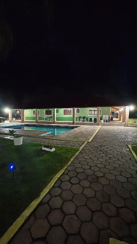 A piscina iluminada à noite, vista do gramado